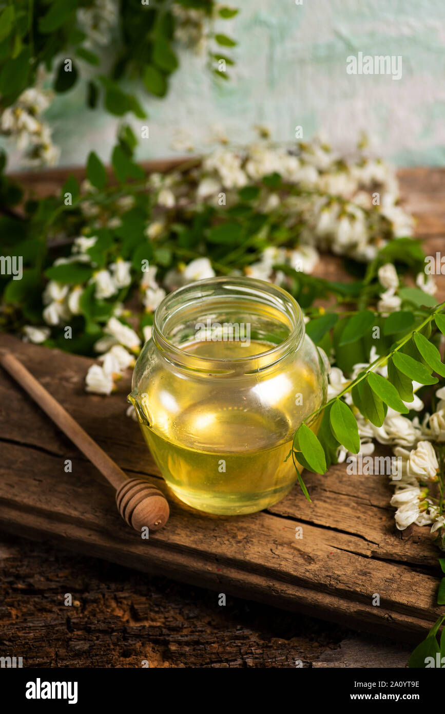 Le miel dans un pot avec des fleurs d'acacia sur une table Banque D'Images