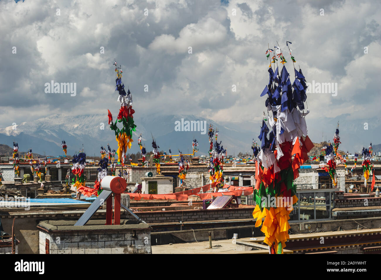 Les drapeaux de prières volent de poteaux sur les toits de Lhassa, au Tibet. Banque D'Images