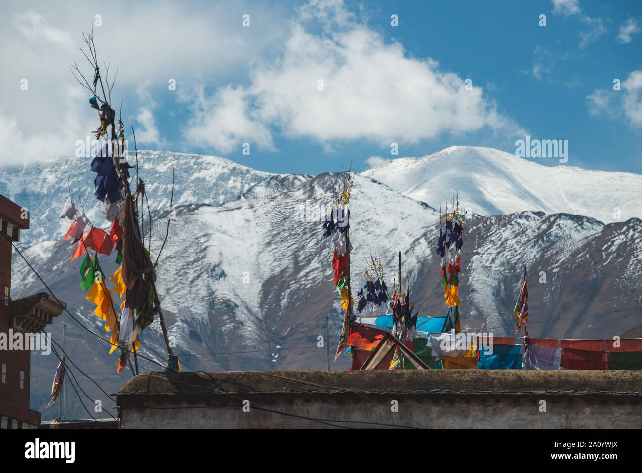 Les drapeaux de prières volent de poteaux sur les toits de Lhassa, au Tibet. Banque D'Images