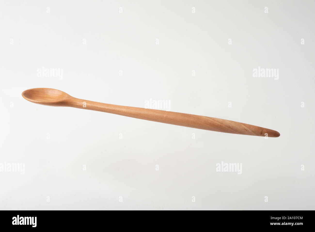 Une cuillère en bois faits à la main à partir de bois de cerisier. Le curvilnear est moderne, mais classique. Banque D'Images