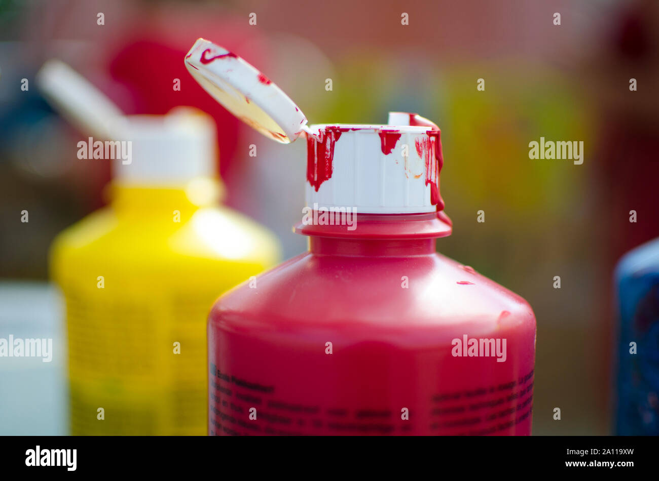 Close up de bouteilles de peinture à base d'eau douce en jaune, rouge et bleu avec open top déjà utilisé. Avec effet de flou ou blured Banque D'Images