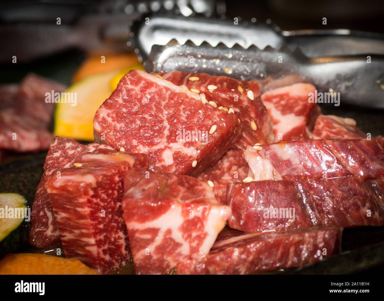 Red la viande bovine prêt pour grill barbecue yakiniku avec graines de sésame et une tong. Banque D'Images