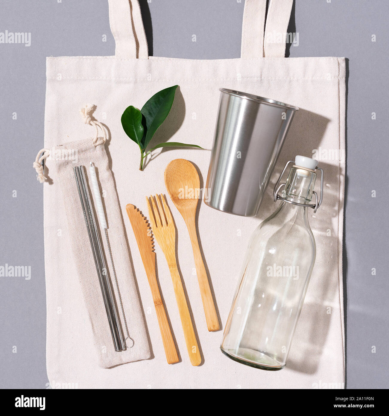 Sacs en tissu, des pots de verre, métal des pailles, des couverts en bambou sur fond gris avec copie espace. Eco Friendly et réutilisation concept. Vue d'en haut. Mise à plat. A Zéro Banque D'Images