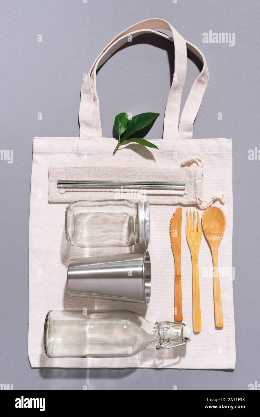 Sacs en tissu, des pots de verre, métal des pailles, des couverts en bambou sur fond gris avec copie espace. Eco Friendly et réutilisation concept. Vue d'en haut. Mise à plat. A Zéro Banque D'Images