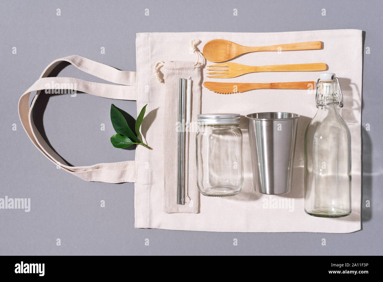 Sacs en tissu, des pots de verre, métal des pailles, des couverts en bambou sur fond gris avec copie espace. Eco Friendly et réutilisation concept. Vue d'en haut. Mise à plat. A Zéro Banque D'Images