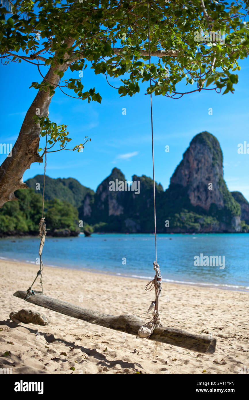 Un Hängeschaukel weißem Strand und Meer vor blauem Felsenlandschaft suis Railay Beach à Krabi en Thaïlande. Banque D'Images