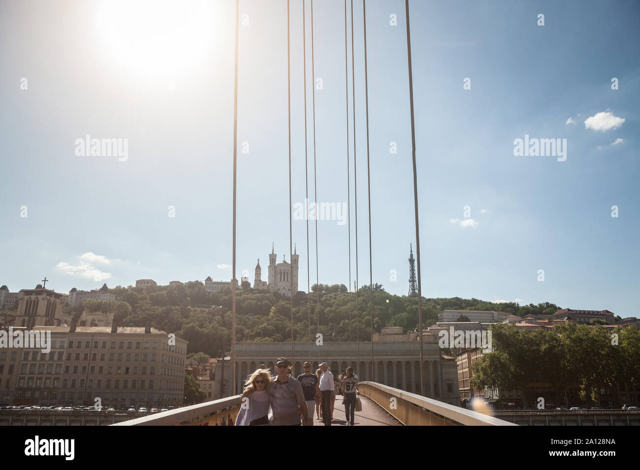 LYON, FRANCE - 13 juillet 2019 : Les gens qui passent sur un pont en face de la Colline de la colline de Fourvière avec sa basilique emblématique et la Cour de Justice, un Banque D'Images