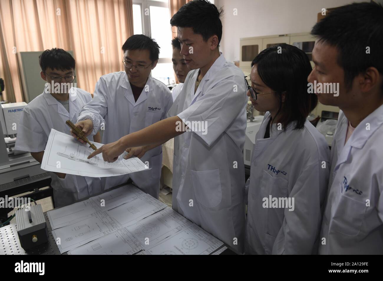 (190923) -- Chengdu, 23 septembre 2019 (Xinhua) -- Des chercheurs de l'Université des Sciences et Technologies de Chine (UESTC) discuter de la structure du jet de plasma dans l'UESTC à Chengdu, dans le sud-ouest de la province chinoise du Sichuan, le 19 septembre 2019. Récemment, des chercheurs du département de physique et d'électronique, de l'école des sciences et de l'ingénierie électronique à l'UESTC ont développé avec succès un nouvel ordinateur de poche jet plasma après deux ans d'expériences scientifiques. Plasma sont excités par l'énergie des micro-ondes. Par la conception d'une structure particulière de l'intérieur du jet de plasma et la buse, le l Banque D'Images