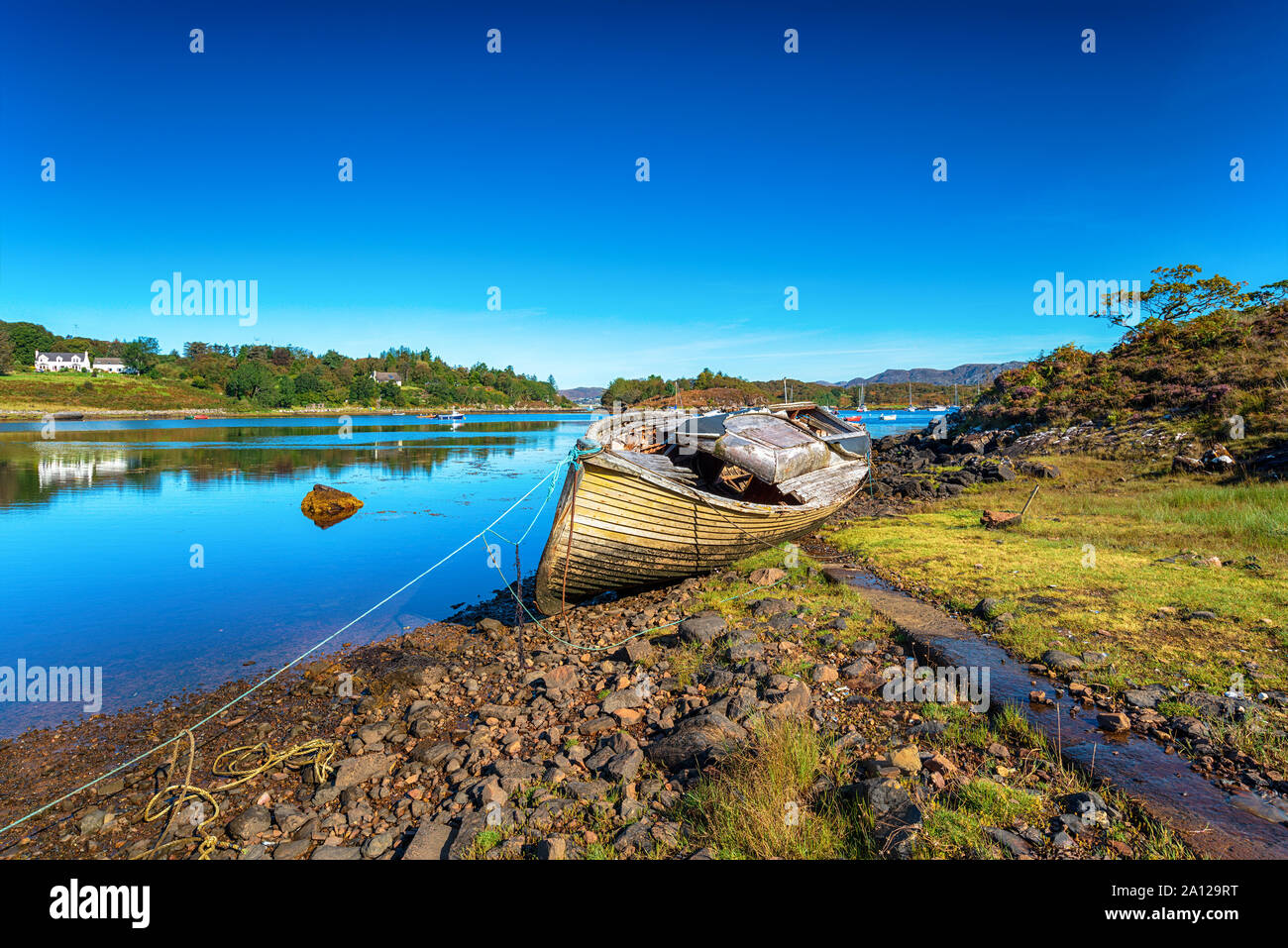 Un vieux bateau de pêche sur la rive du Loch Gair à Badachro dans les Highlands d'Ecosse Banque D'Images