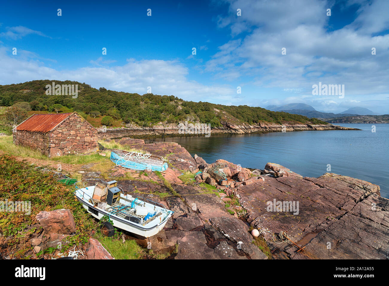 Vieux bateaux et un croft avec un toit en tôle rouillée sur la berge à Kenmore, un petit hameau sur la presqu'île en Kraainem Wester Ross, Ecosse Banque D'Images