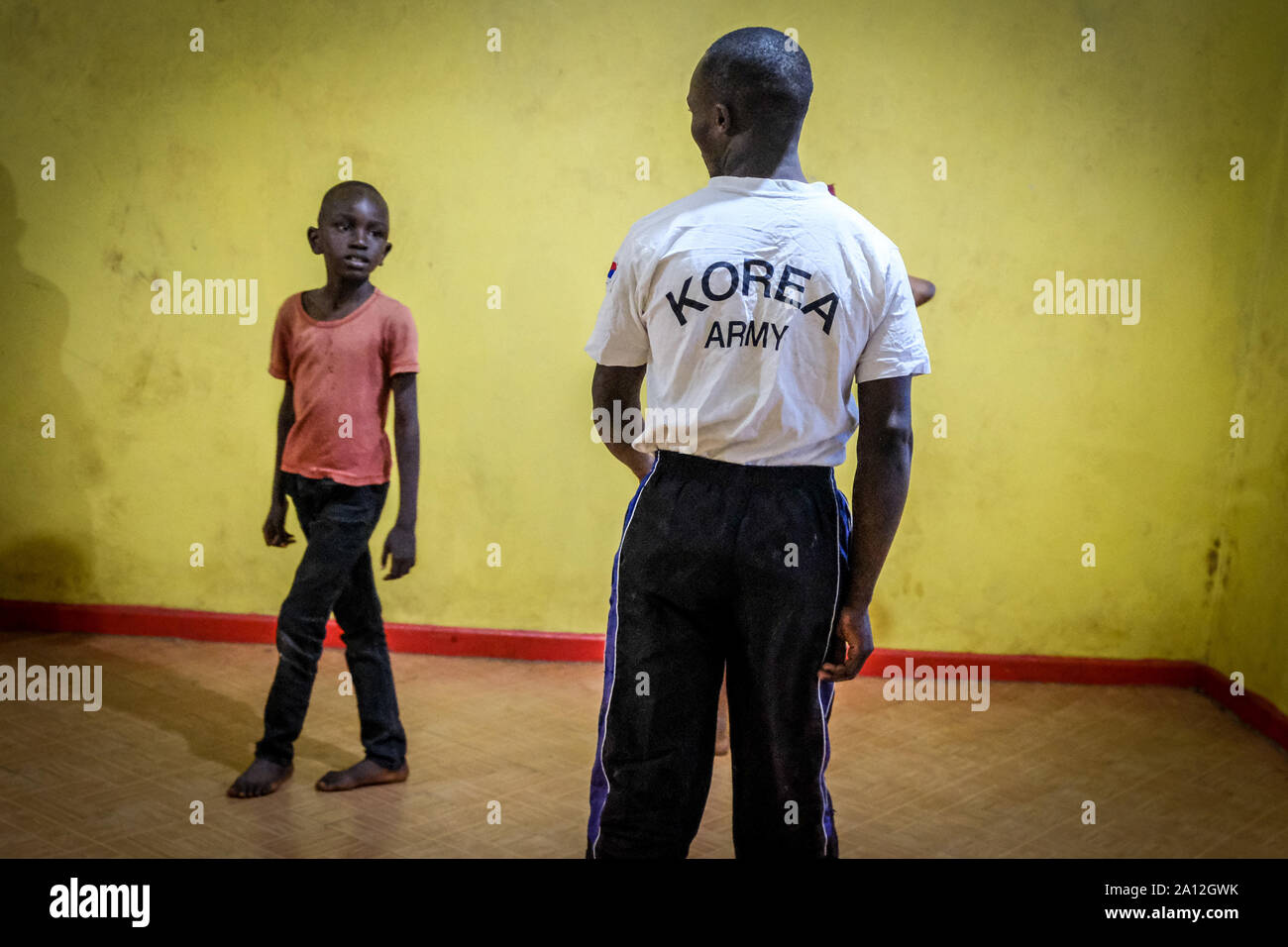 Stephen Coach enfants durant la session de formation.Pour les personnes vivant dans les bidonvilles de Kibera, le sport est une des activités quotidiennes malgré les luttes quotidiennes et bouscule pour faire une vie. En raison de l'augmentation de la question des enfants à la violence familiale et la violence sexuelle qui se produit à chaque fois autour de différentes parties de la communauté, ce qui a rendu les jeunes adolescents comme Stephen qui a une expérience en taekwondo Accueil Accueil Compétences déplacer à demander aux parents de laisser leurs enfants train Compétences et connaissances des arts martiaux et d'auto-défense en cas d'urgence. Banque D'Images