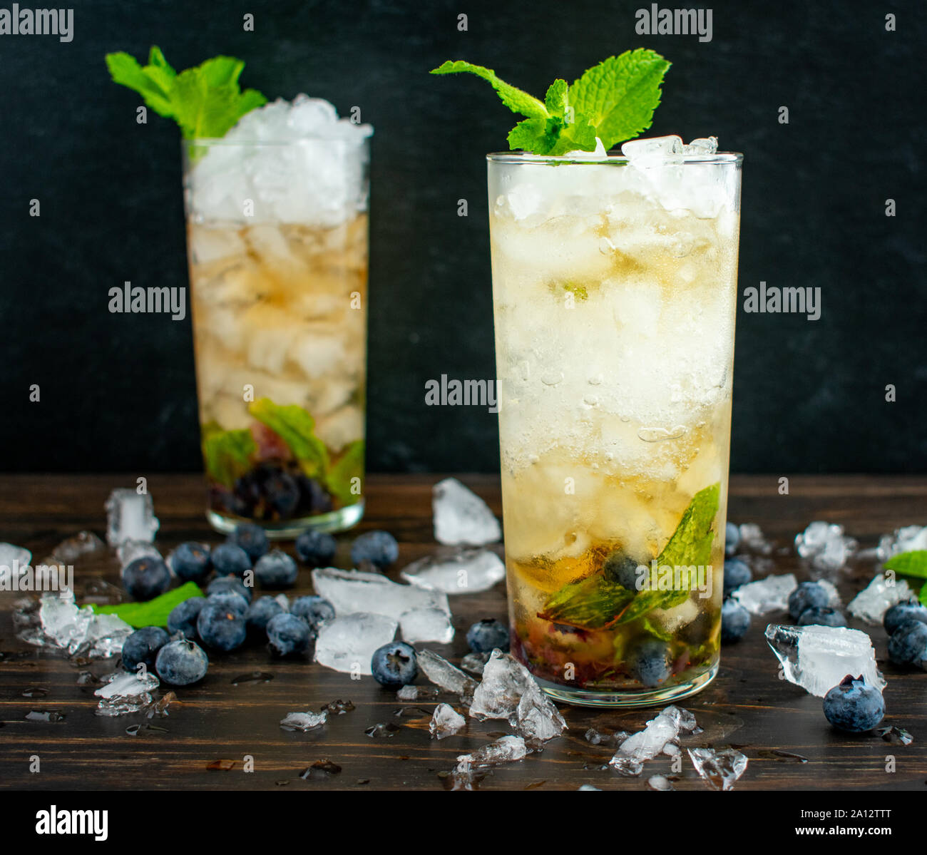 Blueberry Mint Julep Cocktails avec garniture : Deux cocktails à Bourbon whiskey, bleuets, et des feuilles de menthe sur la glace concassée Banque D'Images