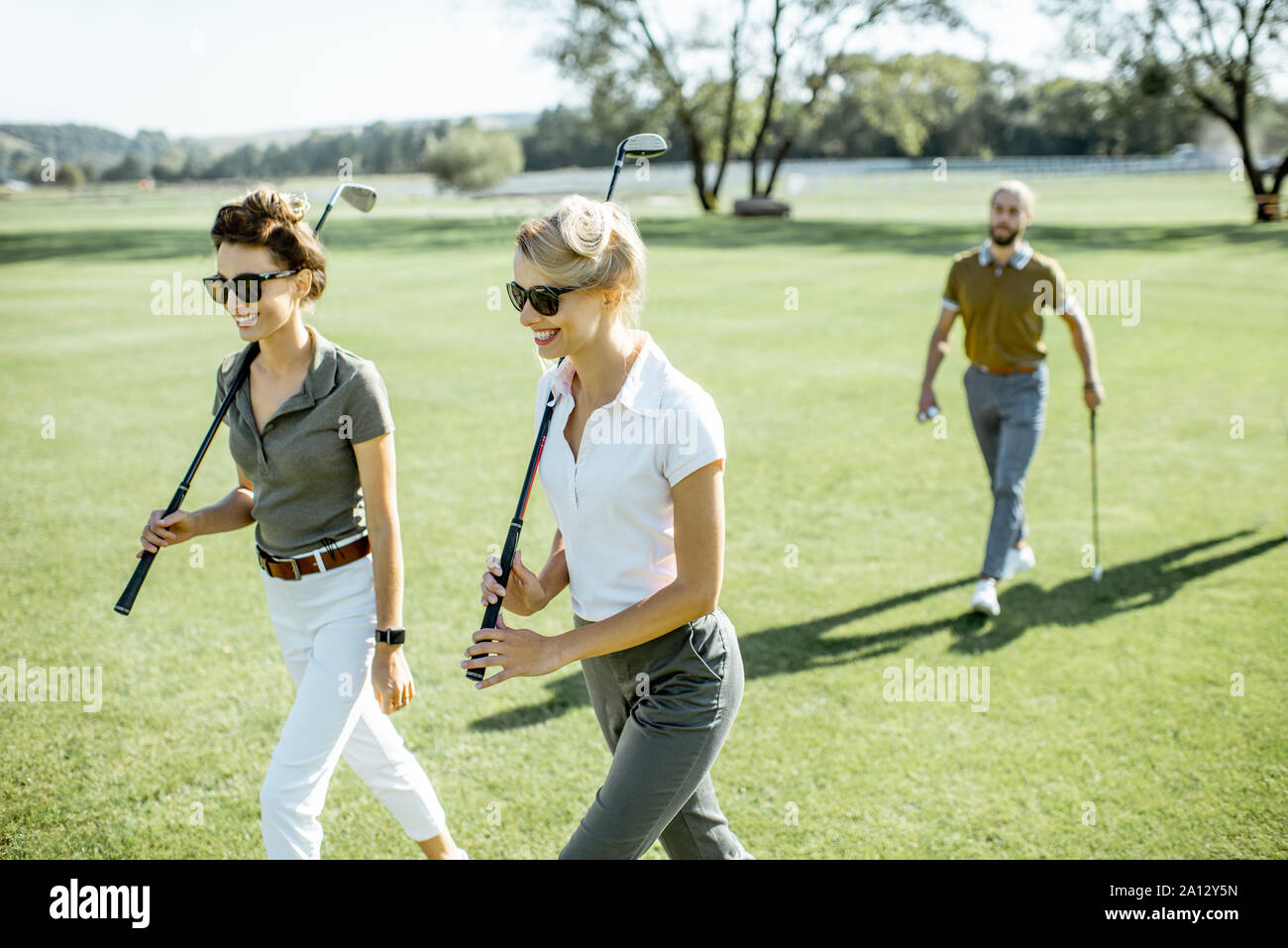 Les deux meilleurs amis de marcher tout en jouant un jeu de golf putters pendant sur un cours sur une journée ensoleillée Banque D'Images