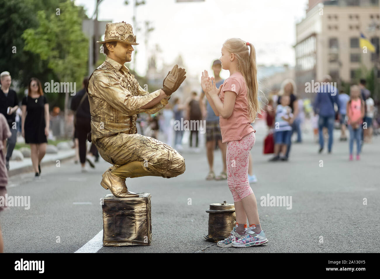 Kiev, Ukraine, le 26 mai 2019. Petite fille joue patty-cake jeu avec l'artiste de rue, statue vivante sur la rue Khreshchatyk Banque D'Images