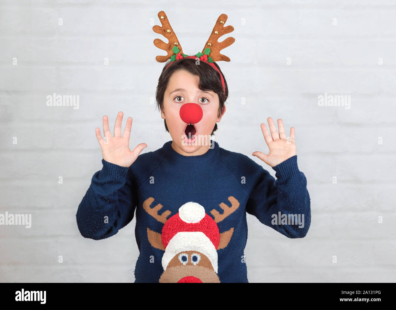 Joyeux Noël.enfant dans un costume de noël Renne Rudolph sur fond brique Banque D'Images