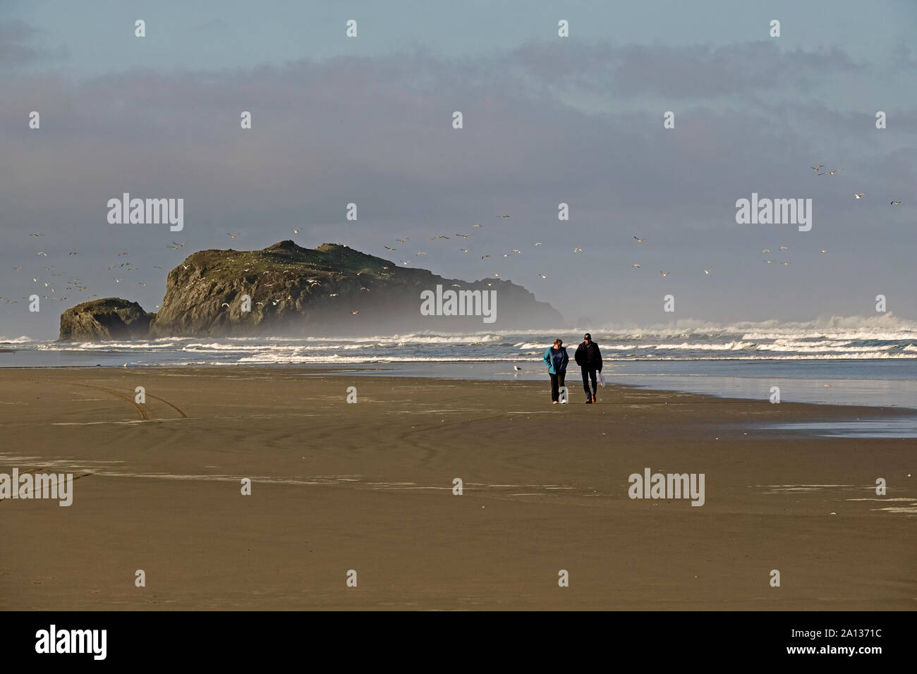 Un couple d'âge moyen se promener le long de la plage de l'océan Pacifique vide à Bandon, Oregon, Oregon le long de la côte du Pacifique. Banque D'Images