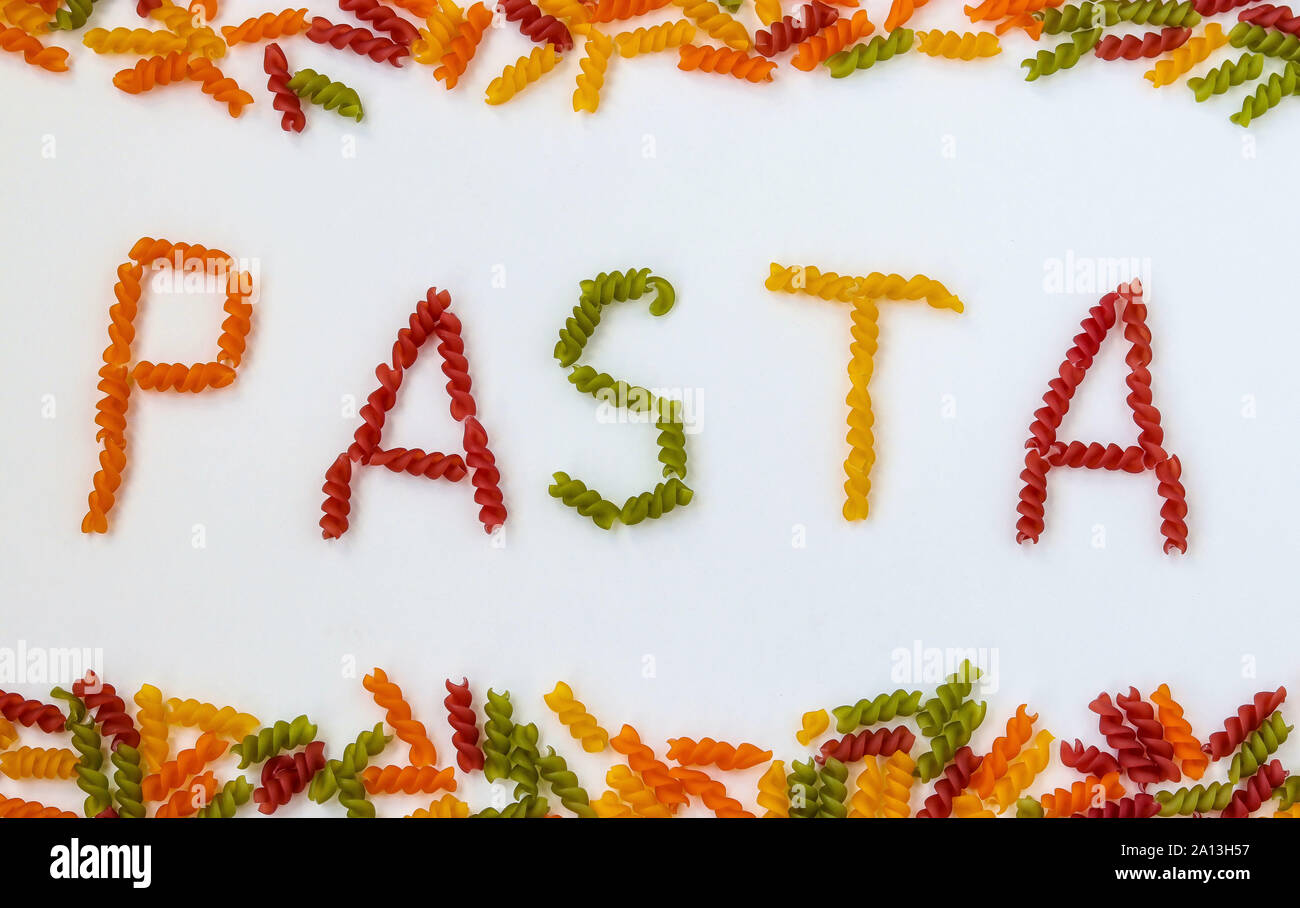 Les Fusilli pâtes multicolores sur un fond blanc, lettrage formé à partir de pâtes pâtes crues, l'orientation horizontale Banque D'Images