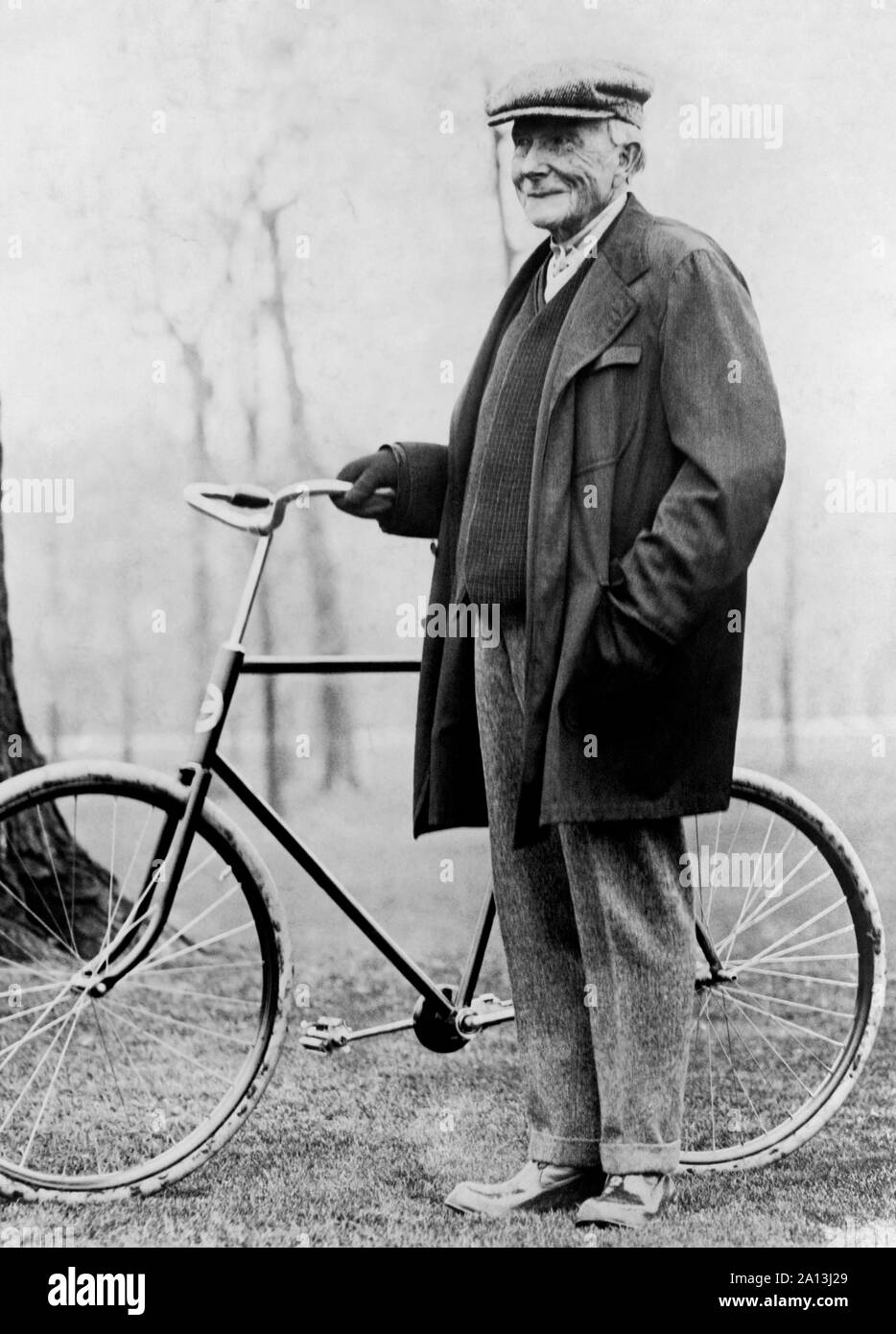 Magnat des affaires américain John D. Rockefeller debout à côté d'un vélo en 1913. Banque D'Images