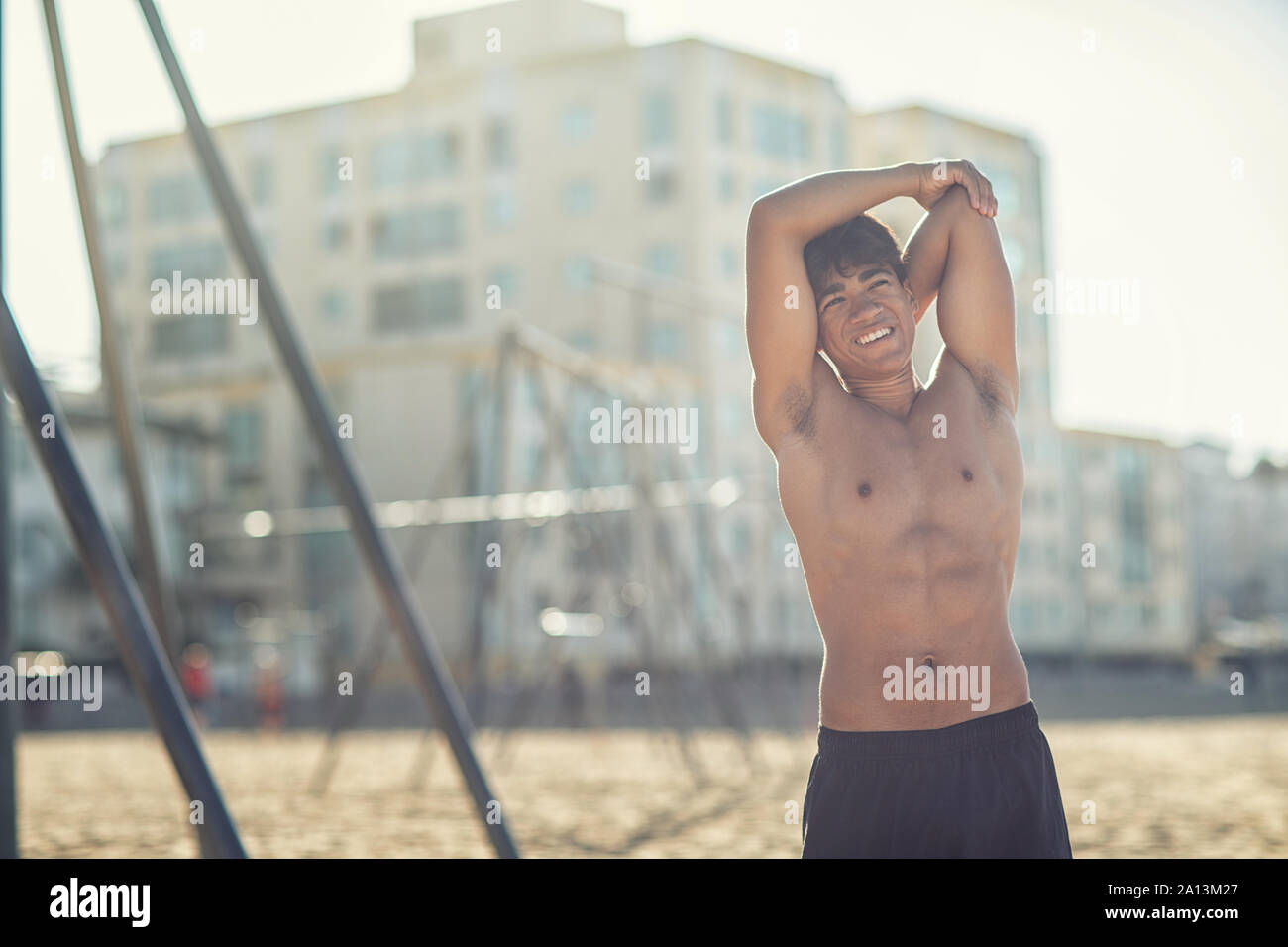Portrait d'un beau jeune homme musclé en maillot de bain sur le muscle Beach à Santa Monica à côté de l'équipement de conditionnement physique Banque D'Images