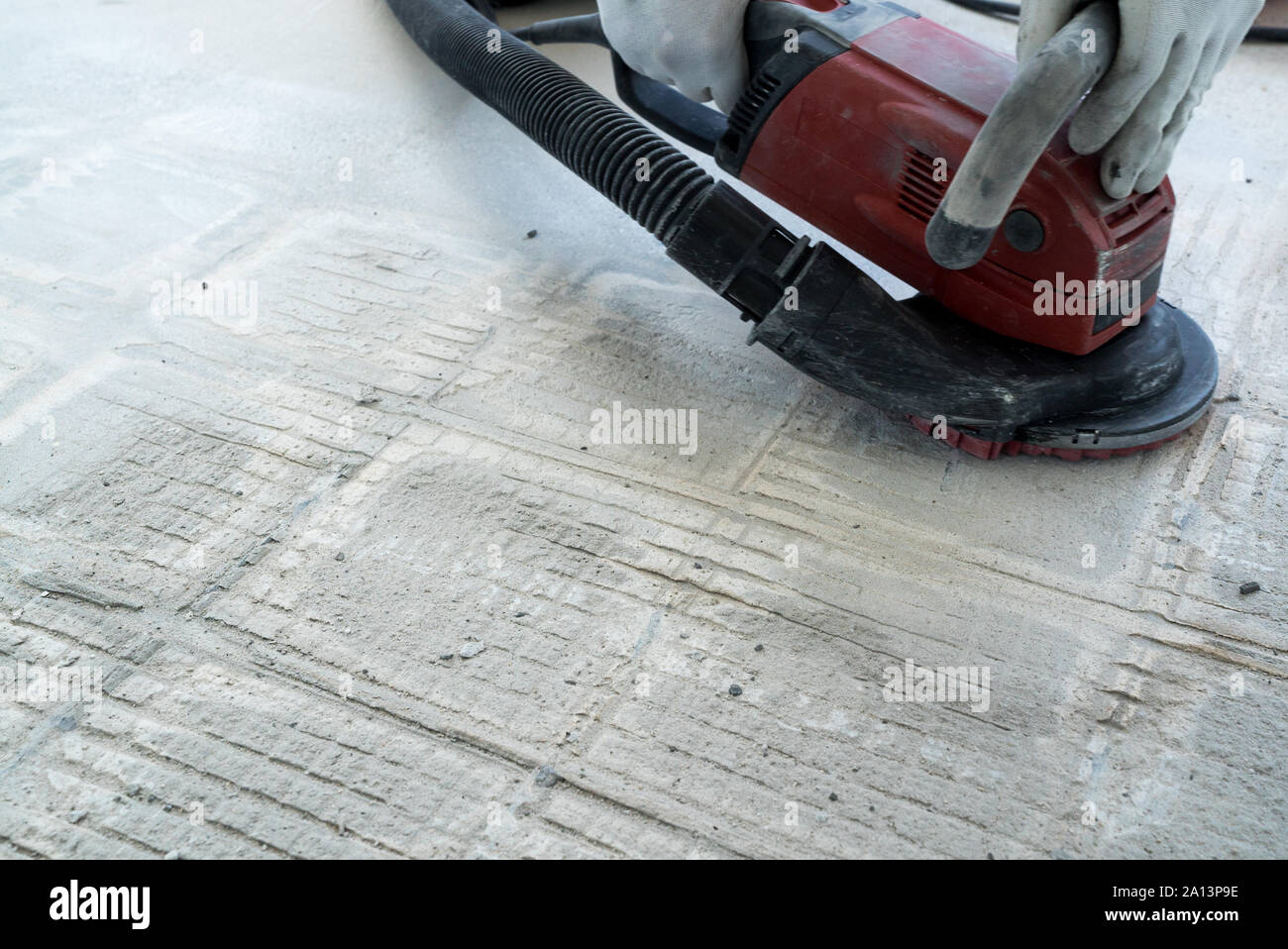 Un travailleur de la construction utilise une meuleuse béton pour enlever  la colle de carrelage et de résine pendant les travaux de rénovation Photo  Stock - Alamy