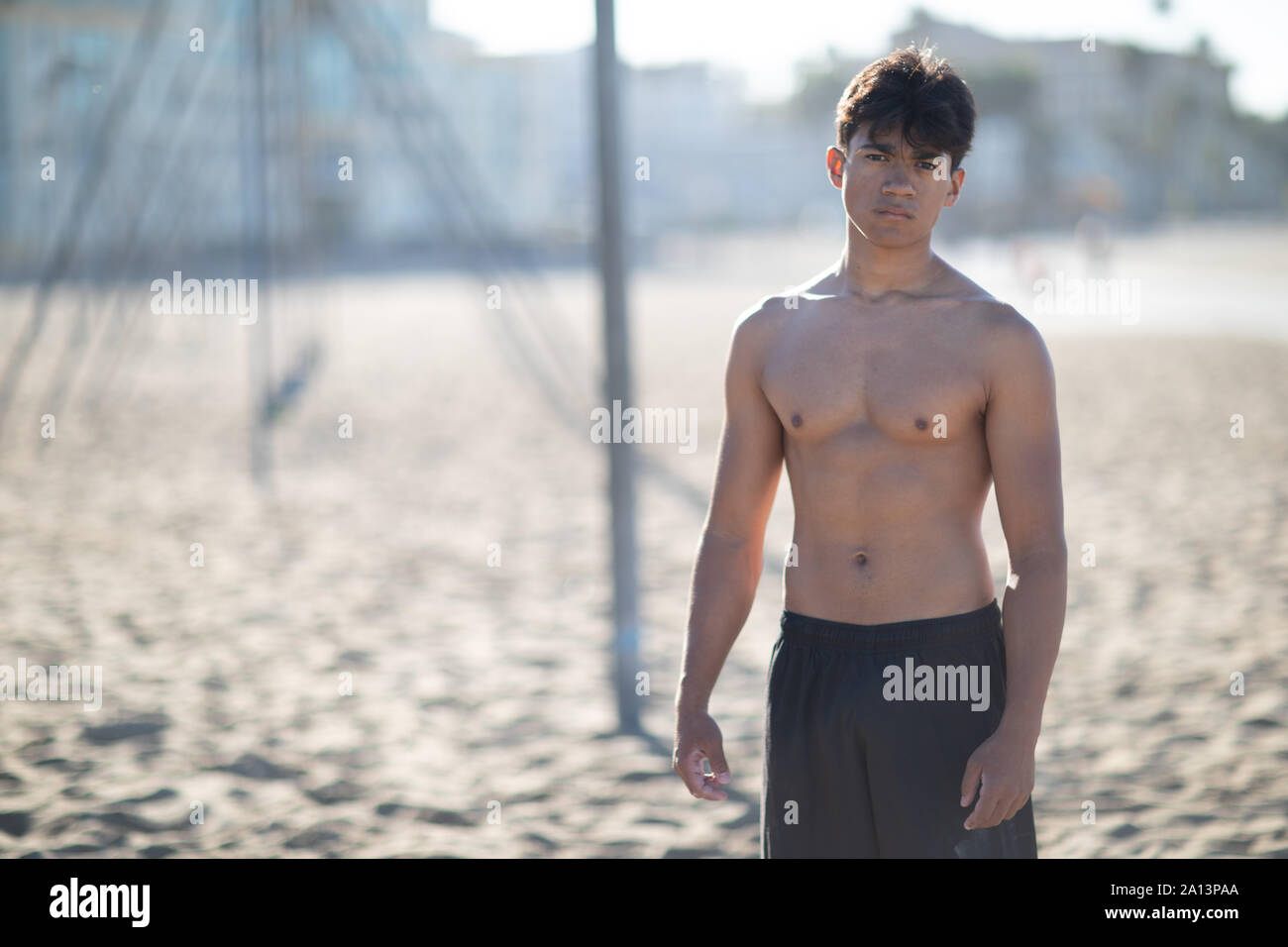 Portrait d'un beau jeune homme musclé en maillot de bain sur le muscle Beach à Santa Monica à côté de l'équipement de conditionnement physique Banque D'Images