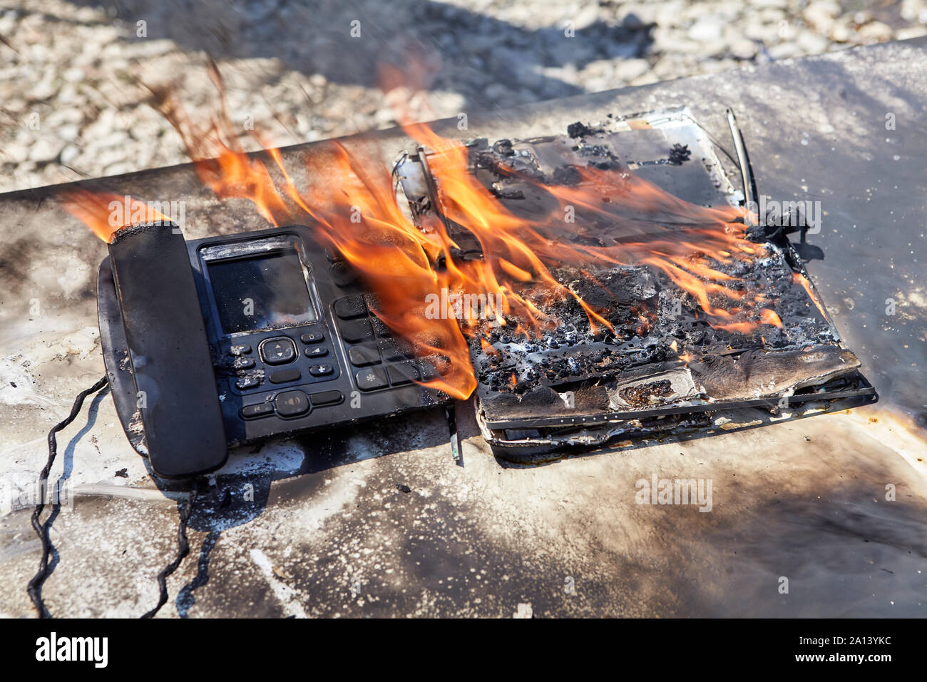 Un incendie dans le bureau, une flamme détruit un téléphone filaire et d'un  ordinateur portable, un bureau 24 enflammé. Un téléphone fixe burns dans un  bureau d'incendie Photo Stock - Alamy