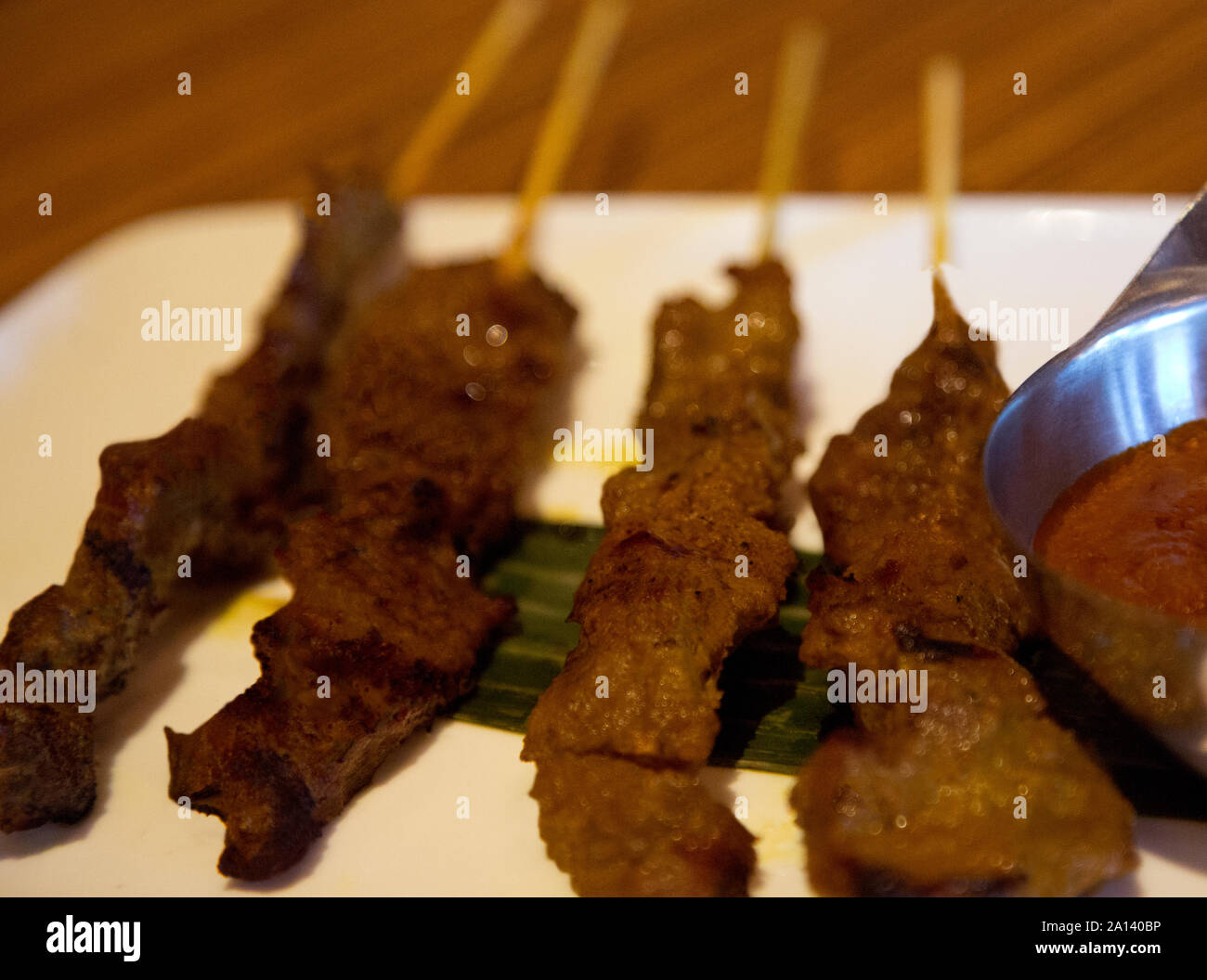 Satay de boeuf avec sauce aux arachides déposer sur des feuilles de banane on white plate Banque D'Images