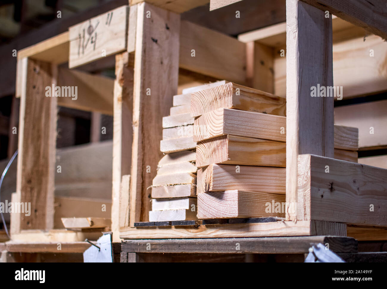 Des piles de taille 2 x 4 longueurs de bois sont stockés dans des caisses en bois dans un atelier de travailleurs du bois Banque D'Images