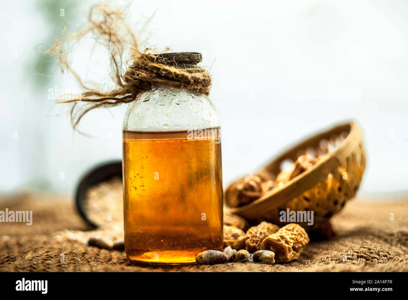 Organique de kharek ou dattes séchées dans un panier ou un panier avec ses extraits de plantes médicinales de l'huile bénéfique dans une bouteille transparente sur le sac de jute su Banque D'Images