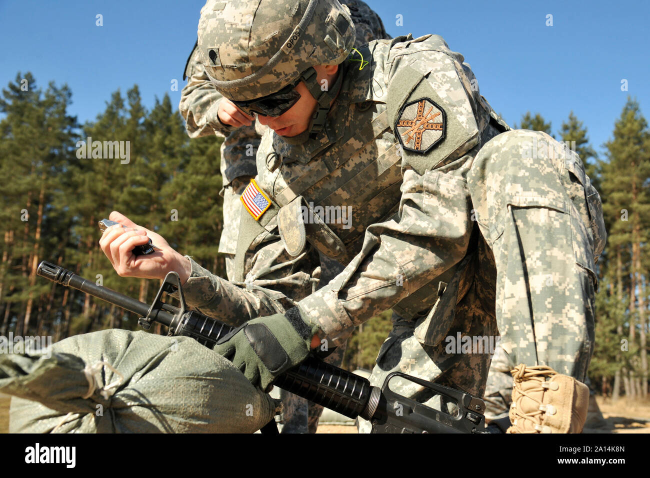 Soldat de l'Armée américaine fait des ajustements à la vue de son fusil M16. Banque D'Images