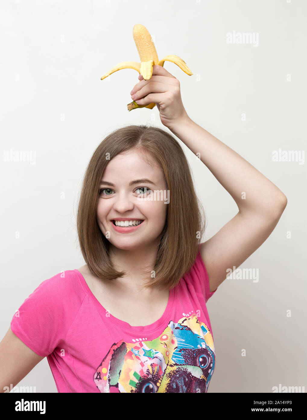 Portrait of smiling caucasian woman girl avec banane jaune dans sa main. Mode de vie sain, des fruits régime végétarien. Banque D'Images