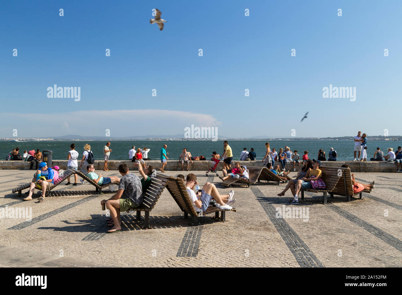 Les gens se détendre à Ribeira das Naus, une promenade en bord de fleuve dans le centre-ville de Lisbonne, Portugal, lors d'une journée ensoleillée en été. Banque D'Images