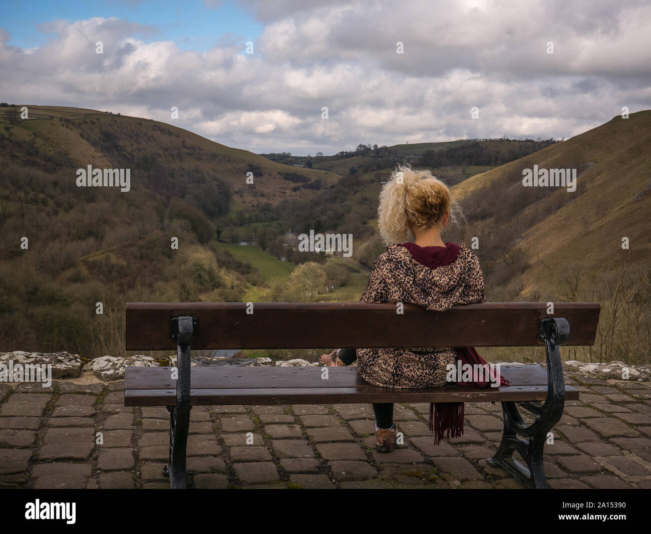 Un adolescent avec des cheveux décolorés assis sur un banc à Monsal Head Banque D'Images