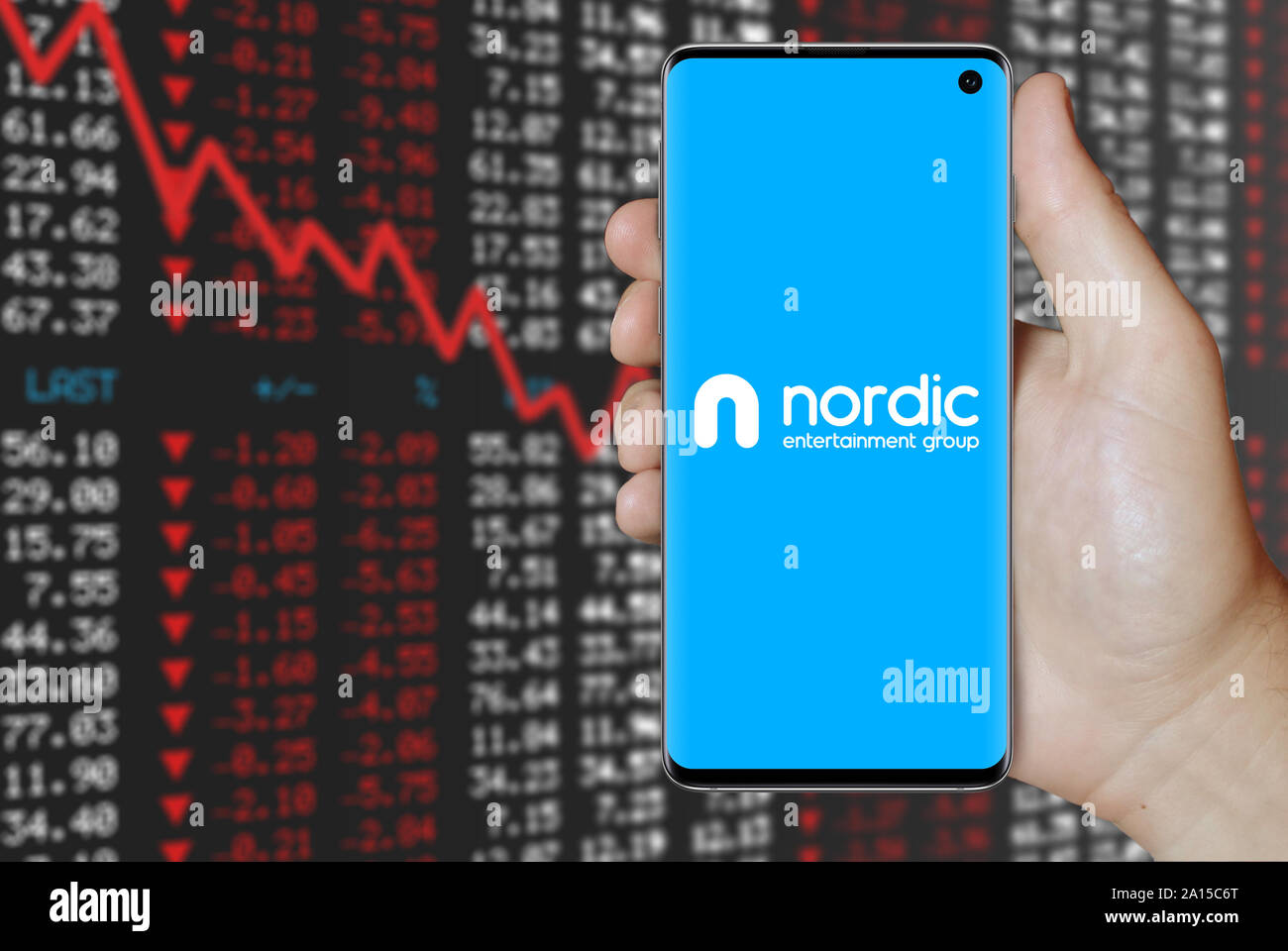 Un homme est titulaire d'un smartphone affichant le logo de Nordic Entertainment Group figurant sur OMX Stockholm. Marché des actions négatives. Credit : PIXDUCE Banque D'Images