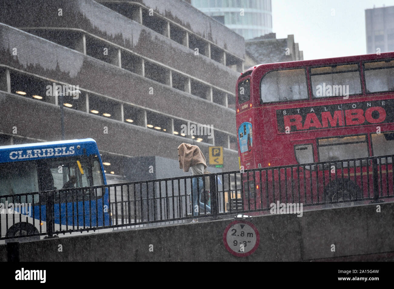 Un piéton utilise leur veste pour un abri contre les fortes pluies dans le centre-ville de Birmingham. Le Met Office a émis une alerte météo jaune d'une grande partie de l'Angleterre et Pays de Galles aujourd'hui, à l'inondation prévu dans certains domaines. Banque D'Images