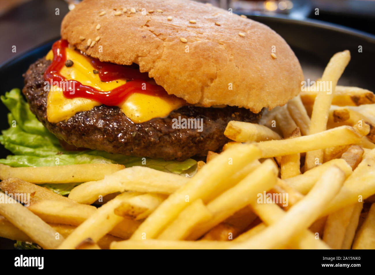 Burger, hamburger au boeuf, frites, ketchup, fromage et laitue, aliments malsains Banque D'Images