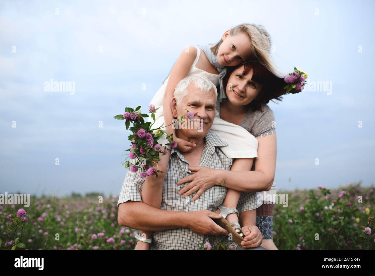 Portrait de petite fille et ses grands-parents avec des fleurs cueillies dans la nature Banque D'Images