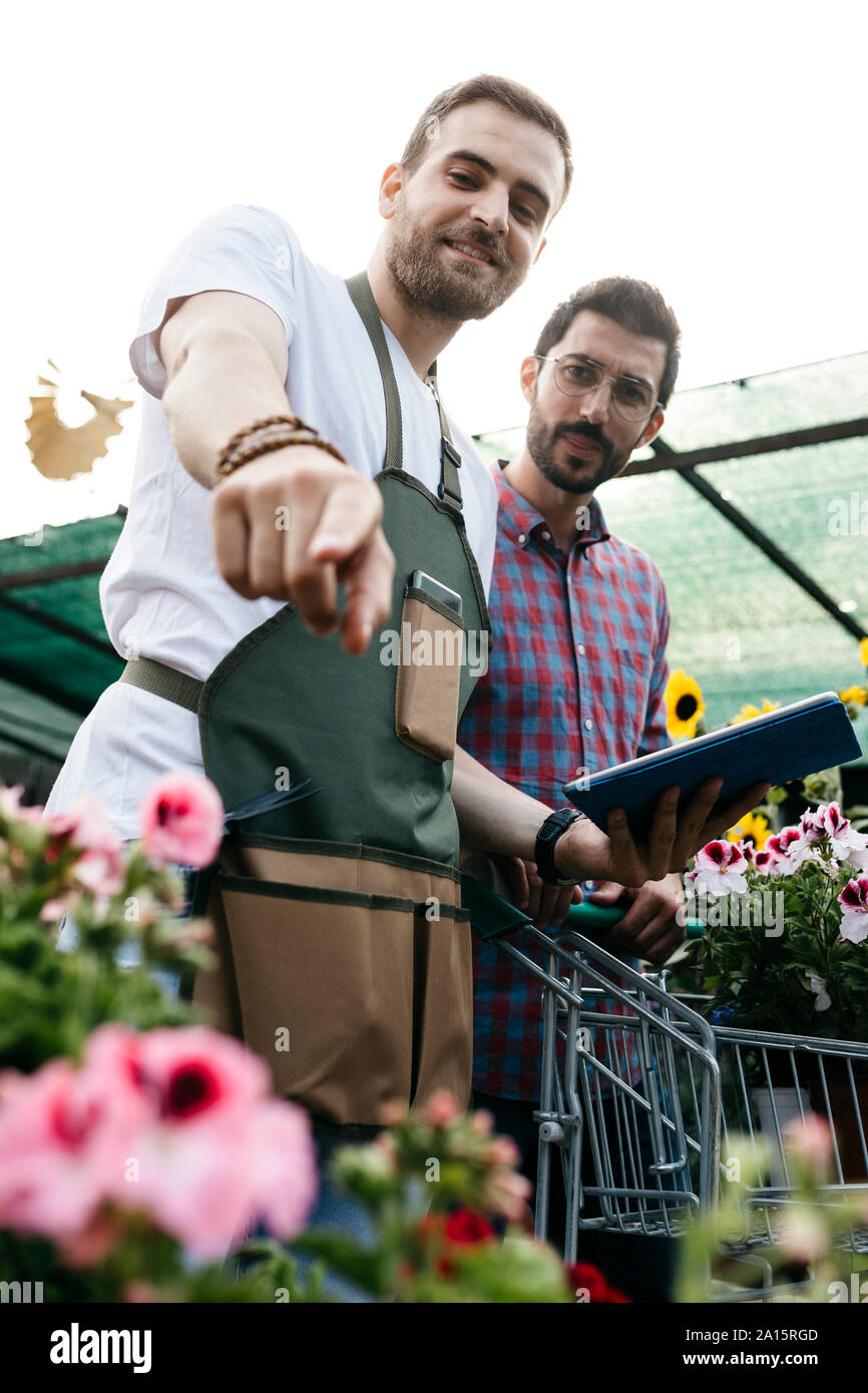 Travailleur avec le comprimé dans une jardinerie conseiller client Banque D'Images