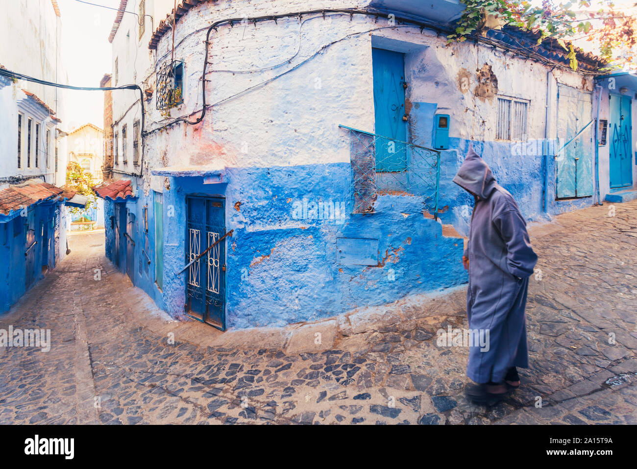 Homme marchant dans la vieille ville de Chefchaouen avec le célèbre blue bâtiments, Chefchaouen, Maroc Banque D'Images