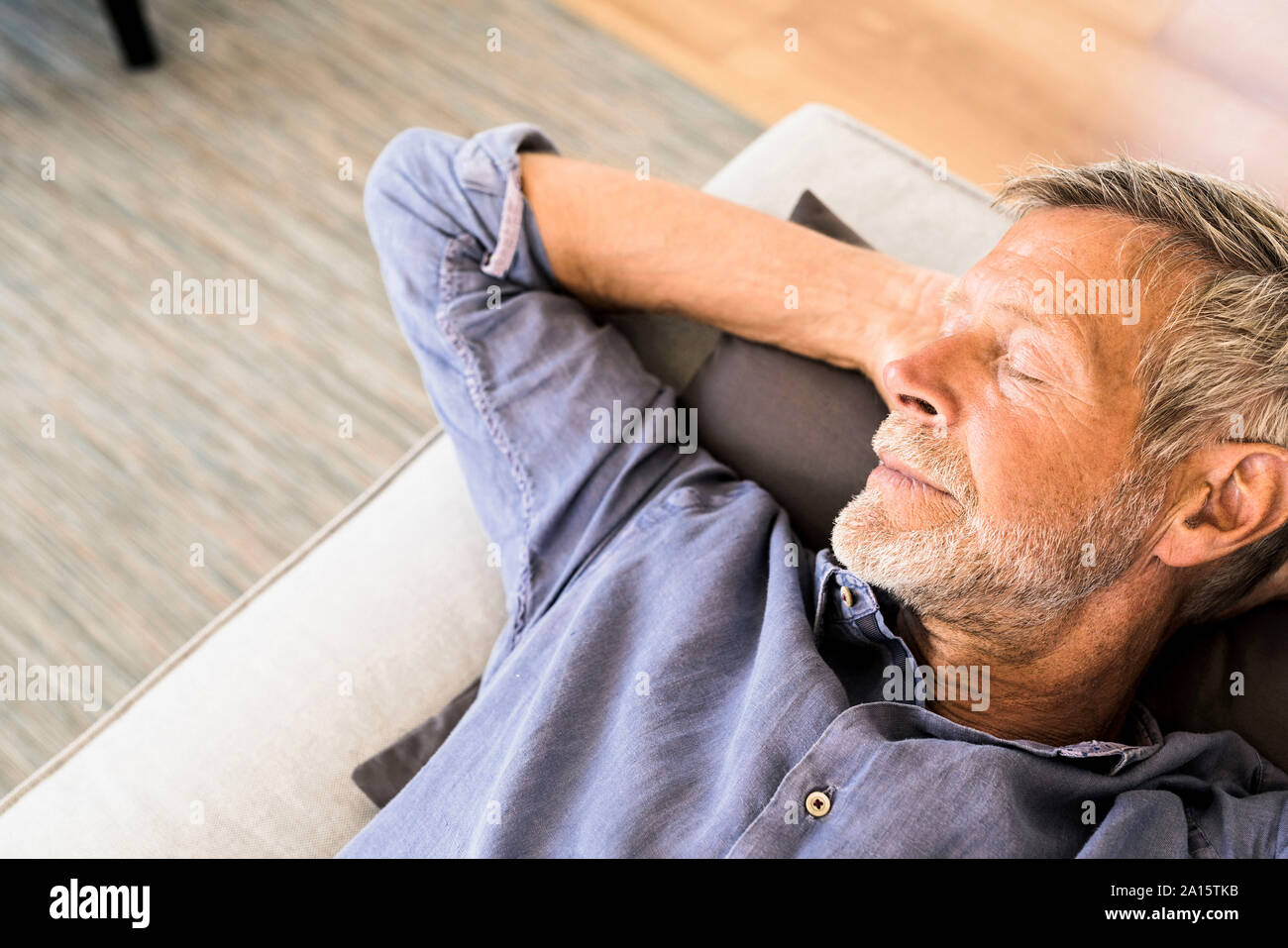 Man lying on couch à la maison prendre une sieste Banque D'Images