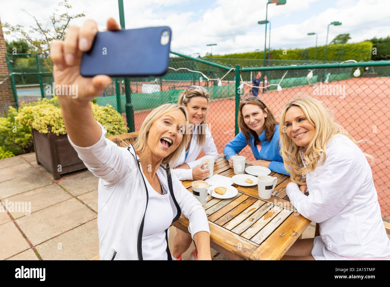 Groupe de femmes prenant un club de tennis à selfies après un match Banque D'Images