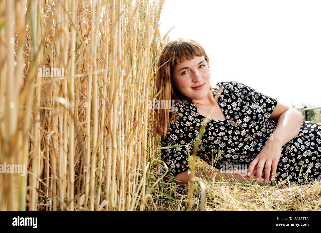 Portrait of smiling young woman wearing dress avec floral design dans la nature Banque D'Images