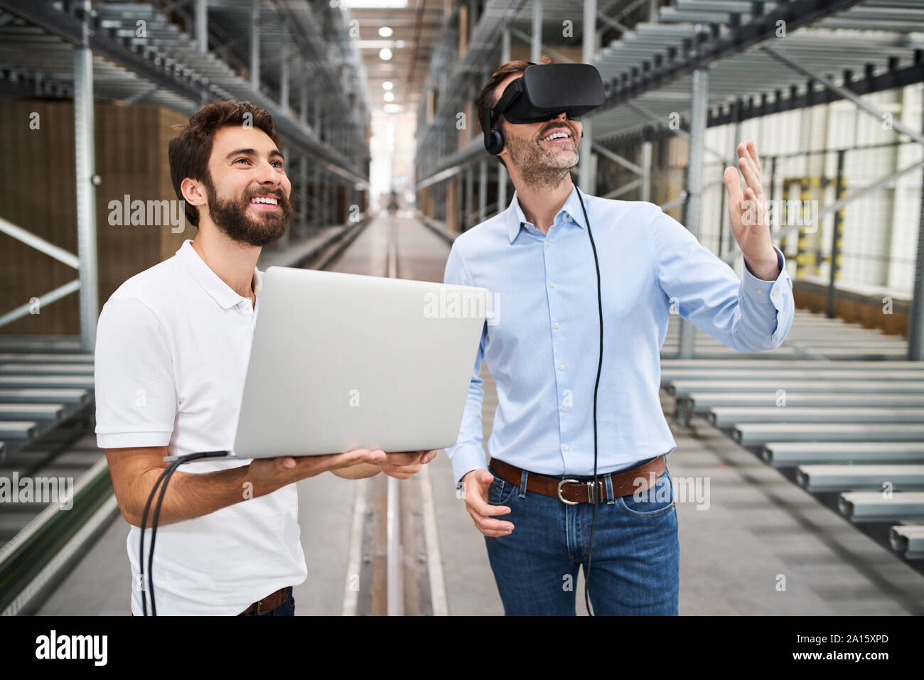 Homme avec portable et businessman wearing glasses VR en usine Banque D'Images
