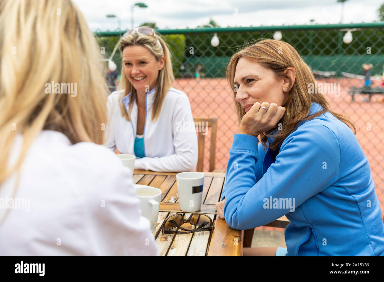 Groupe de femmes parlant dans un café au tennis club après un match Banque D'Images