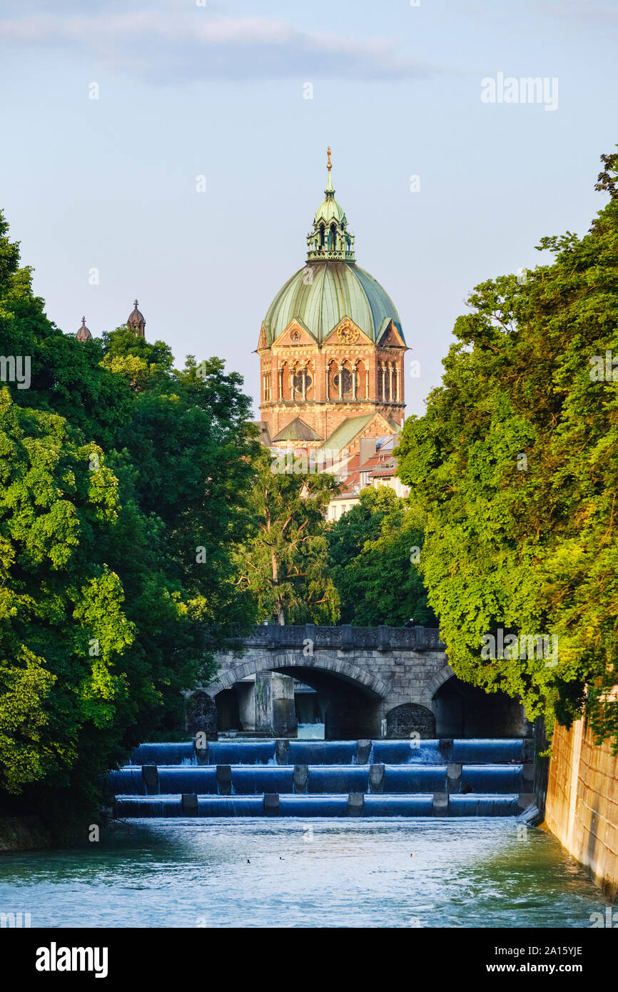 Allemagne, Munich, l'église Saint Luc avec fleuve Isar et Maximiliansbrucke en premier plan Banque D'Images