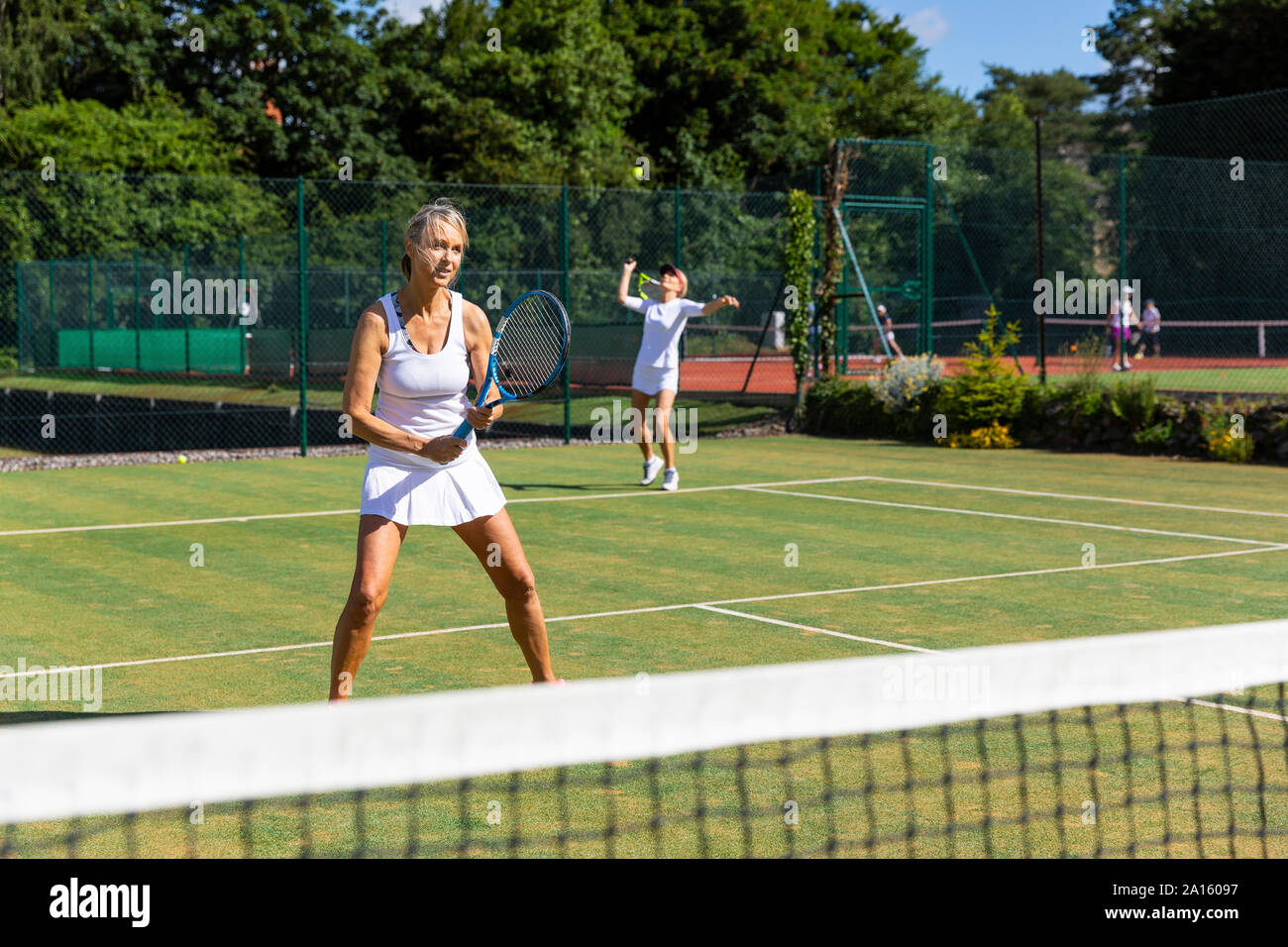 Les femmes mûres pendant un match de tennis sur gazon Banque D'Images