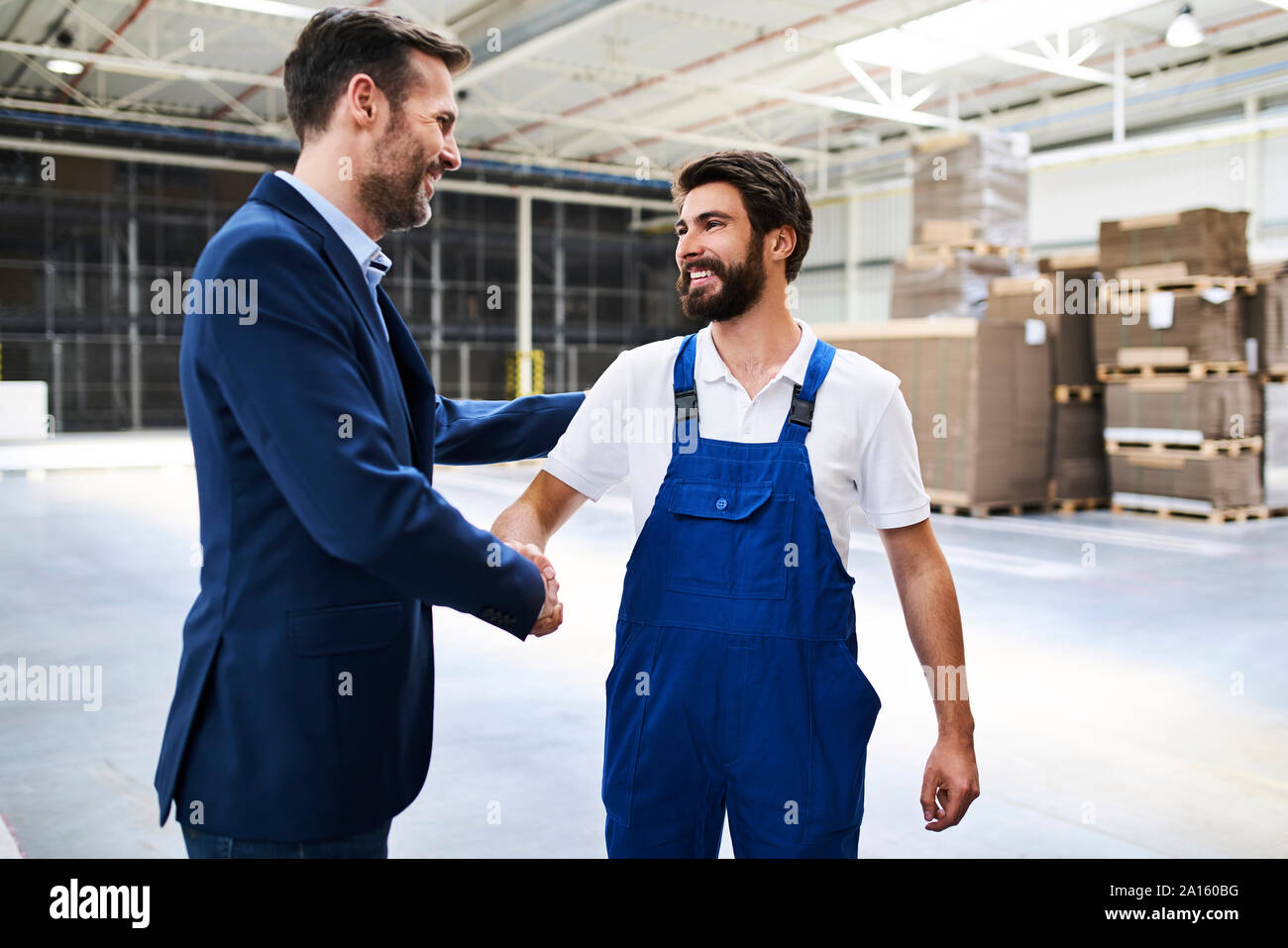 Businessman shaking hands et dans une usine Banque D'Images