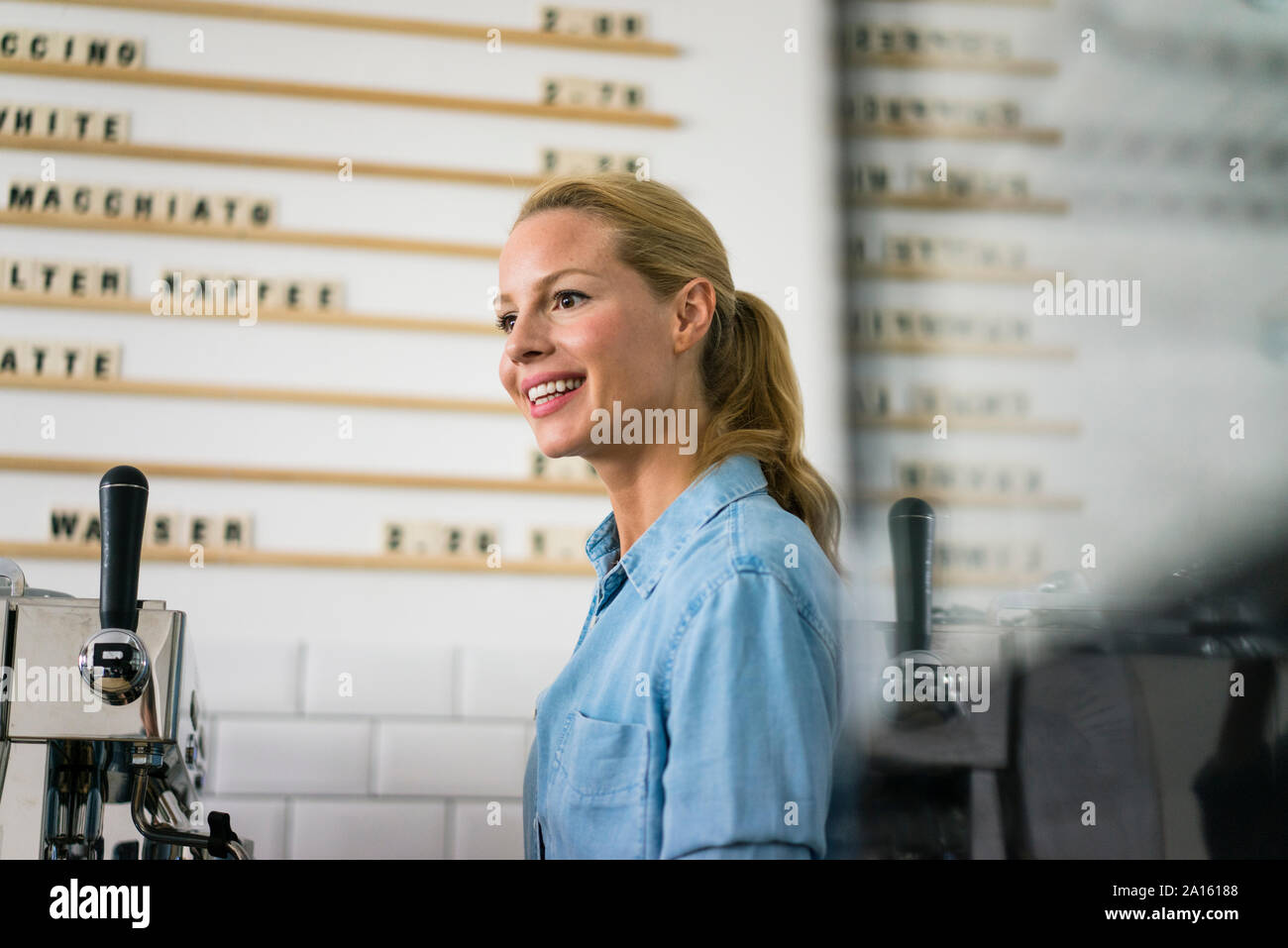 Blonde femme travaillant au comptoir d'un café Banque D'Images