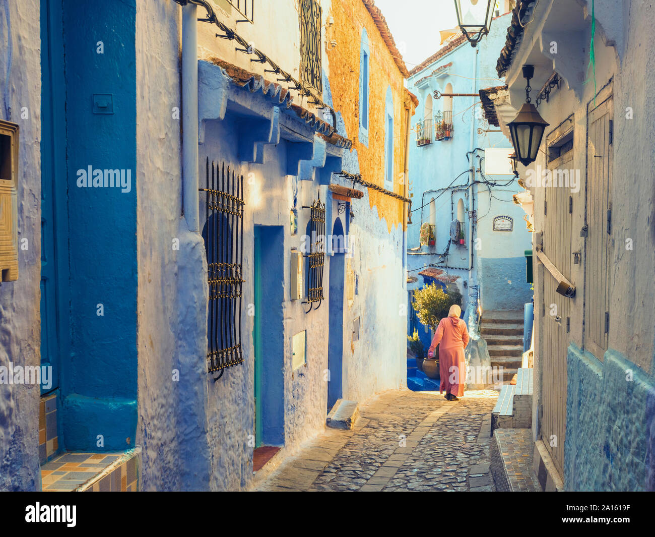 Femme marche dans la vieille ville de Chefchaouen avec le célèbre blue bâtiments, Chefchaouen, Maroc Banque D'Images