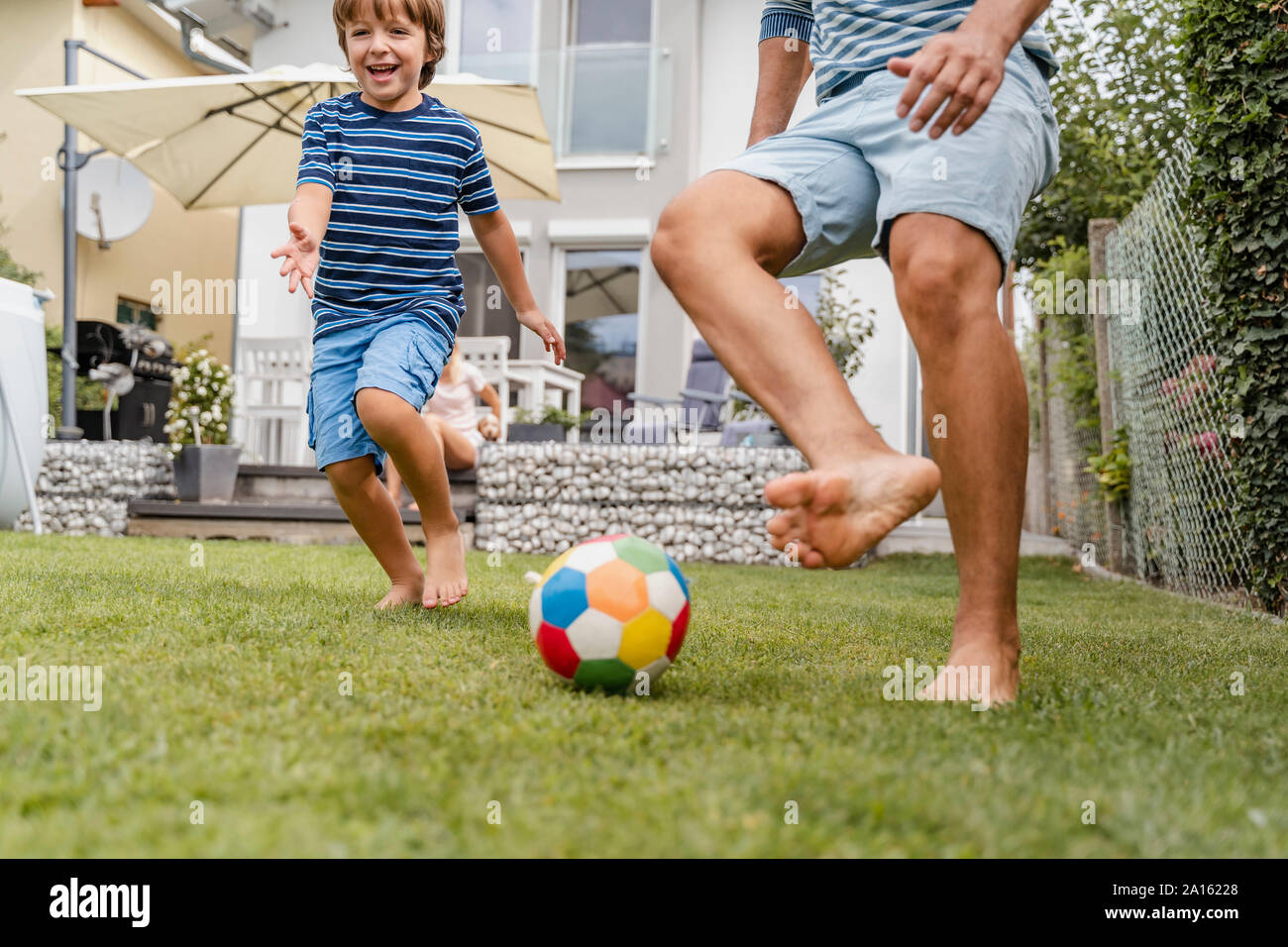 Père et fils à jouer au football dans le jardin Banque D'Images Père et fils à jouer au football dans le jardin Banque D'Images